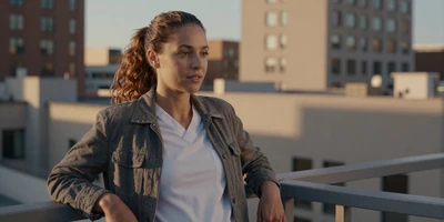 Mixed ethnicity female emergency nurse on a city rooftop at golden hour
