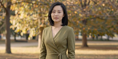 Female endocrinologist in an elegant dress standing in a sunlit park