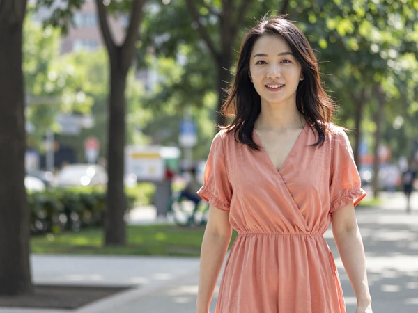 Female pediatrician enjoying a weekend walk in a city park in a summer dress