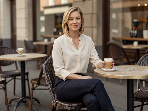 Female pediatrician relaxing at an outdoor cafe with a latte after work